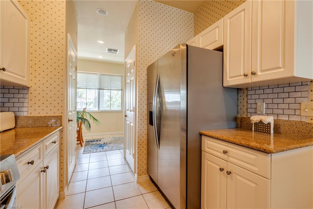 7930 Mahogany Run Lane, Unit 824 Naples, FL 34113 - Photo 13 of 40 a kitchen with stainless steel appliances granite countertop a sink and a refrigerator