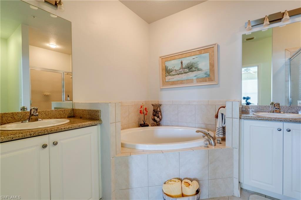 7930 Mahogany Run Lane, Unit 824 Naples, FL 34113 - Photo 25 of 40 a bathroom with a granite countertop sink mirror and vanity