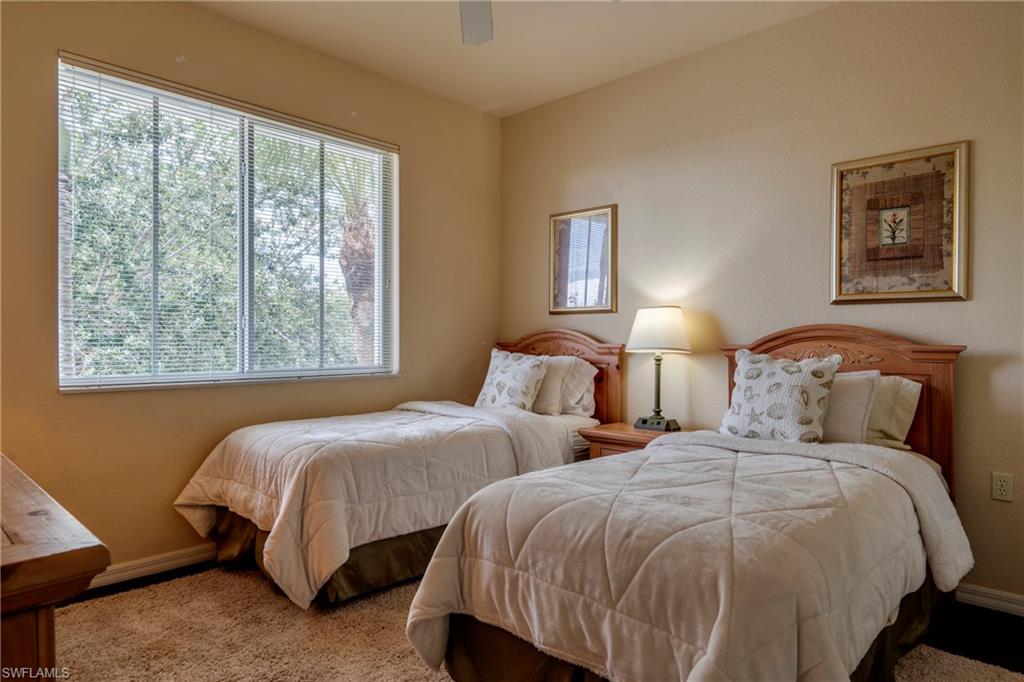 7930 Mahogany Run Lane, Unit 824 Naples, FL 34113 - Photo 7 of 40 a bedroom with two beds and a window