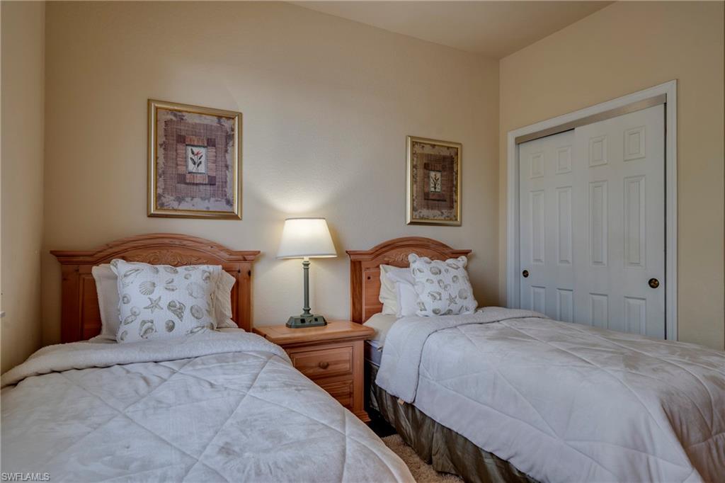 7930 Mahogany Run Lane, Unit 824 Naples, FL 34113 - Photo 8 of 40 a bedroom with beds and lamp