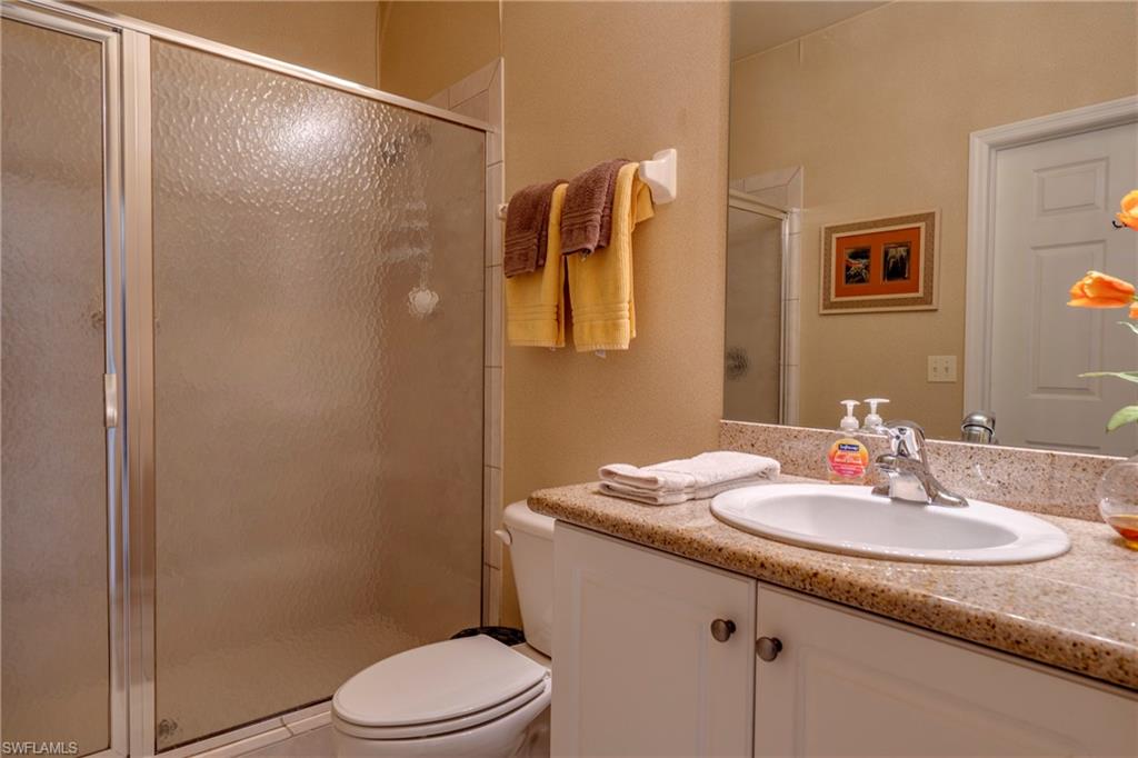 7930 Mahogany Run Lane, Unit 824 Naples, FL 34113 - Photo 9 of 40 a bathroom with a granite countertop sink toilet and shower
