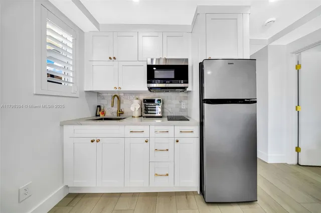 a living room with furniture a flat screen tv and kitchen view