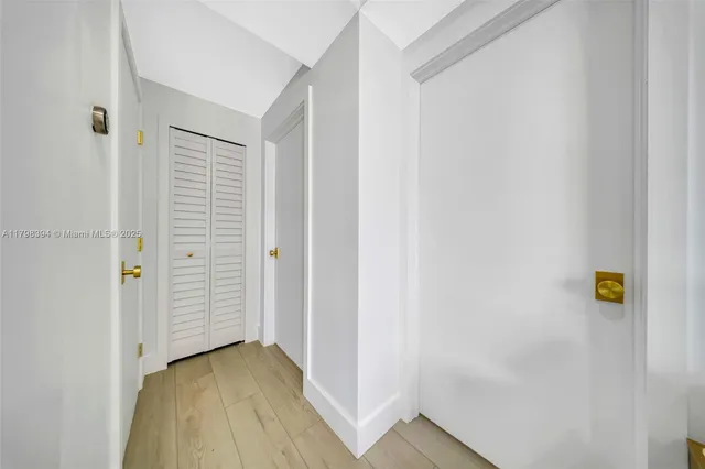 a bedroom with a bed a mirror on dresser and a flat screen tv