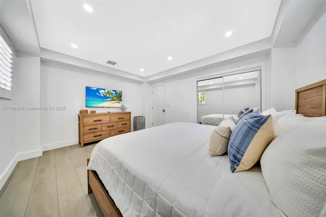 a bedroom with a bed and large windows