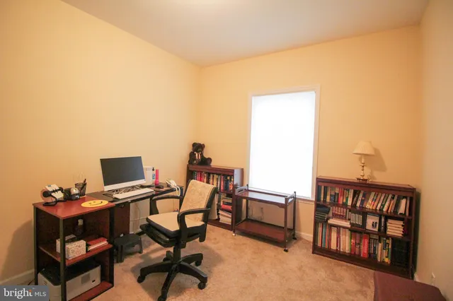 a view of a workspace with furniture and a window