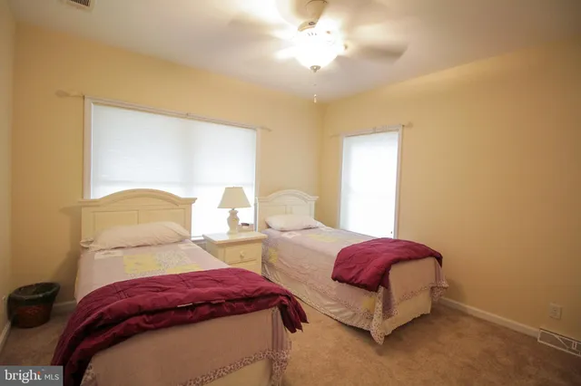 a bedroom with two beds and a chandelier
