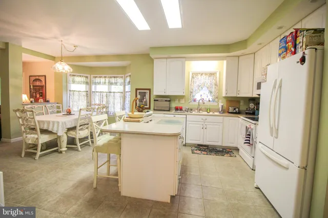 a kitchen with appliances cabinets and chair