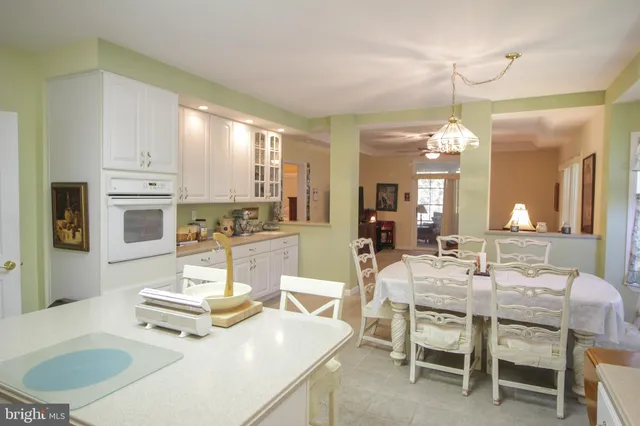 a dining room with wooden floor and kitchen view