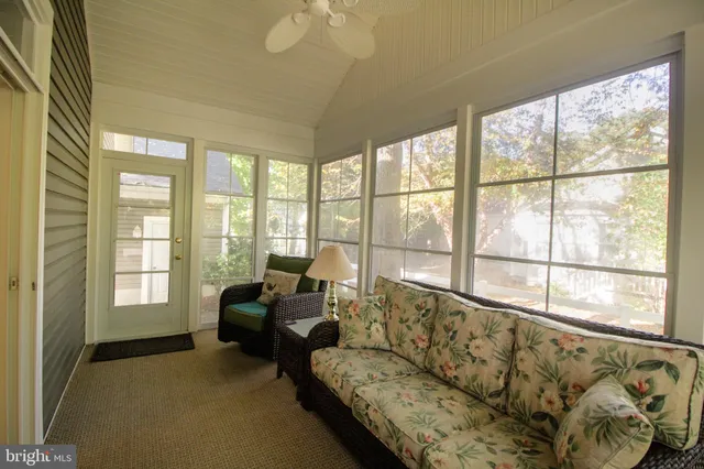 a living room with furniture and floor to ceiling windows