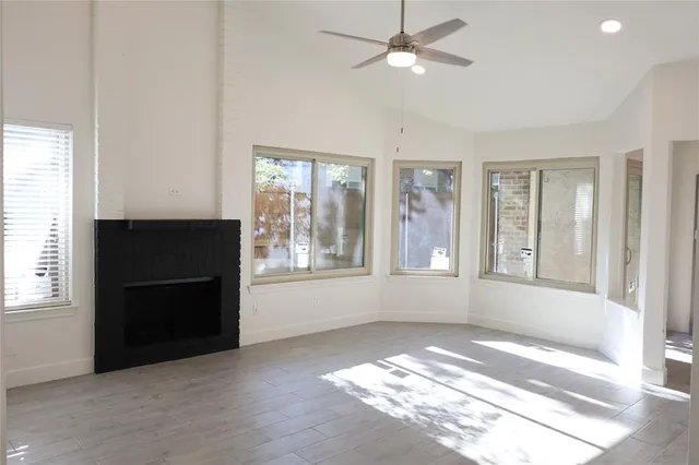 a view of an empty room with a window and a kitchen