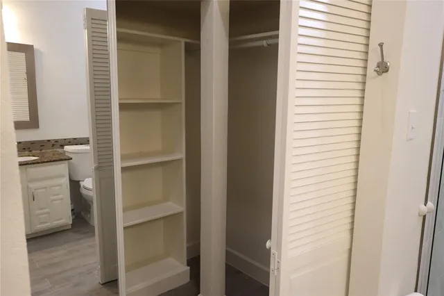 a view of walk in closet and bedroom