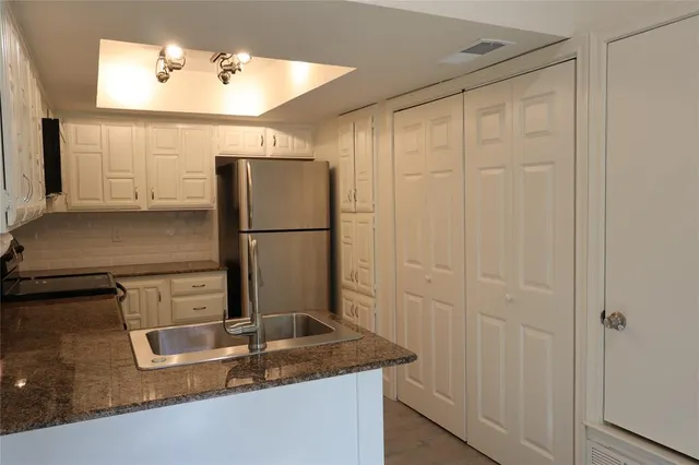 a kitchen with a sink refrigerator and microwave