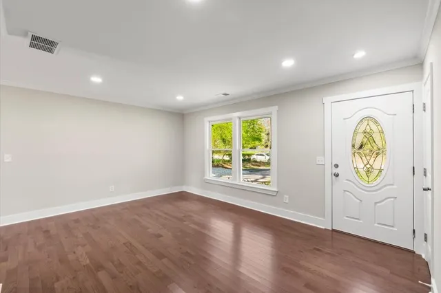 an empty room with wooden floor and window