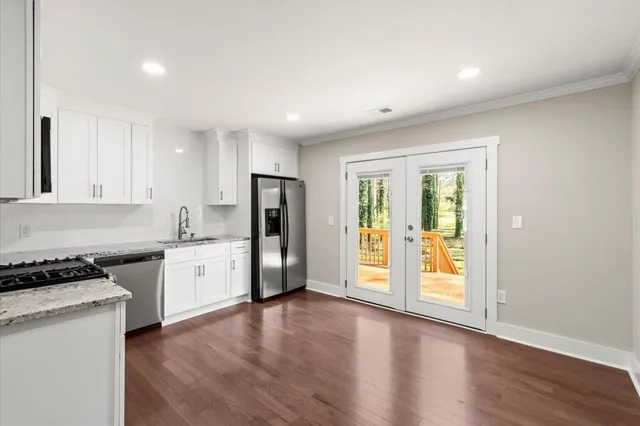 a kitchen with stainless steel appliances granite countertop a refrigerator and a stove top oven