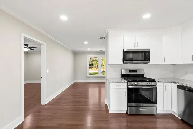 a kitchen with sink a microwave and cabinets