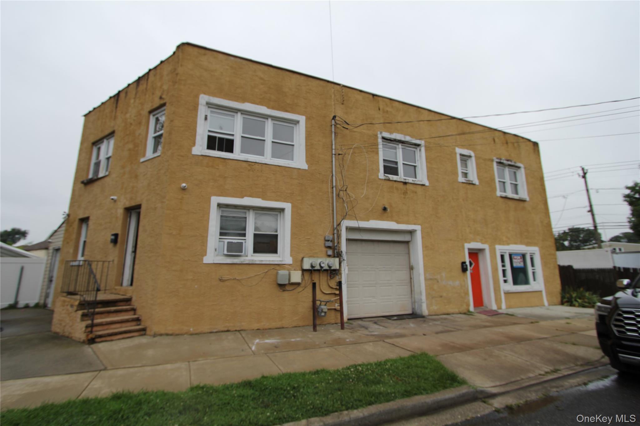 a view of the house with many windows and a yard