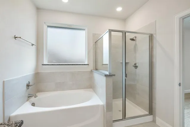 a white bath tub sitting next to a shower