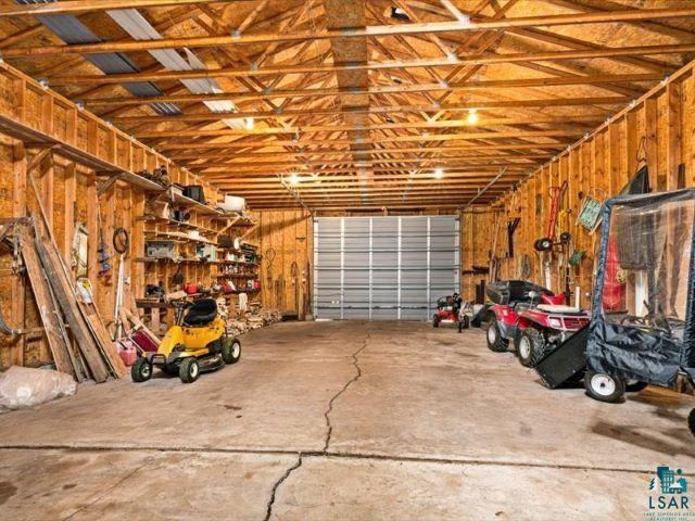 3616 Lavaque Road Hermantown, MN 55811 - Photo 24 of 43 Spacious garage featuring exposed wood framing, concrete flooring, and a large roll-up door