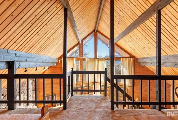 a view of a balcony with wooden floor next to a yard