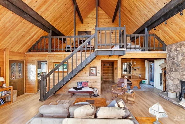 a living room with furniture a fireplace wooden floor and a table