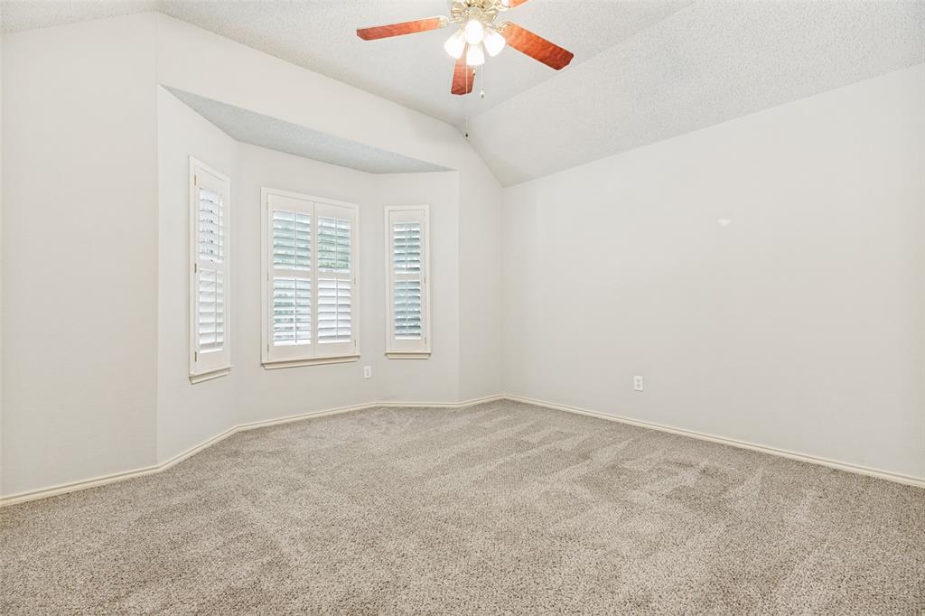 1215 Spring Creek Drive Allen, TX 75002 - Photo 20 of 40 Expansive room featuring a bay window with plantation shutters, vaulted ceiling, and a ceiling fan