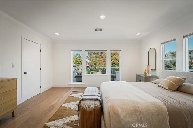 a bedroom with a bed and large windows