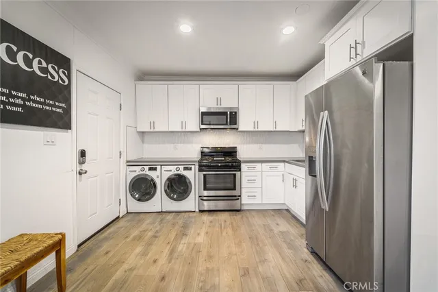 a kitchen with a refrigerator a stove top oven a sink and cabinets