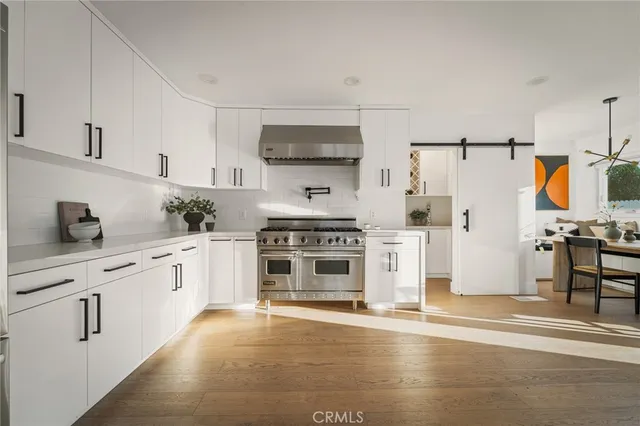 a kitchen with stainless steel appliances a refrigerator stove and white cabinets