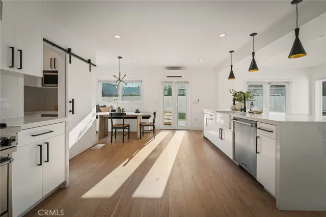 a kitchen with stainless steel appliances kitchen island hardwood floor sink and stove