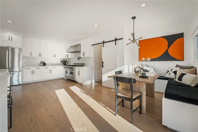 a living room with stainless steel appliances kitchen island granite countertop furniture and a wooden floor