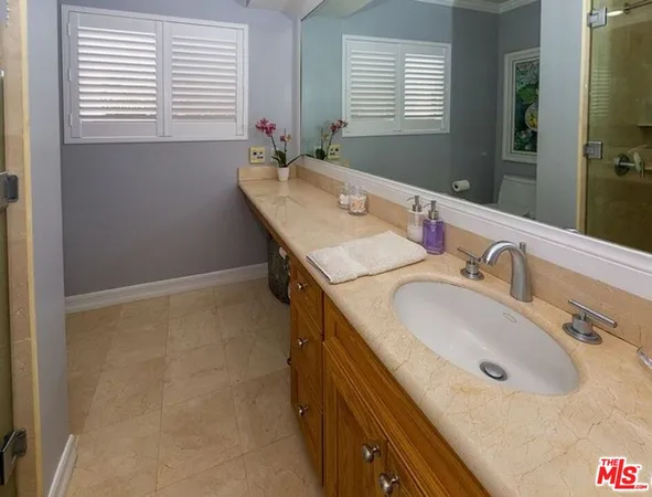 a bathroom with a granite countertop sink and a mirror