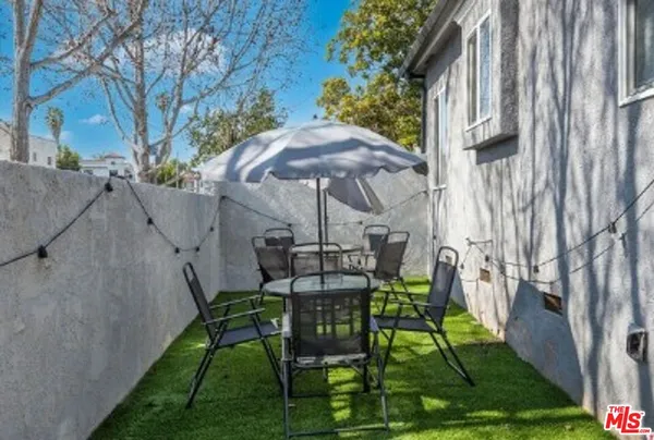 a view of a patio with chair and table under an umbrella