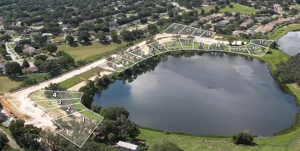 a view of a lake with a yard and mountain in the back