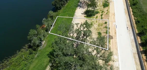an aerial view of a house with a yard and lake view