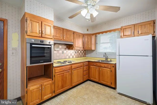 a kitchen with stainless steel appliances granite countertop a refrigerator a sink dishwasher a stove and white cabinets