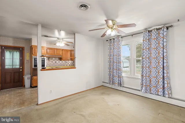 an empty room with windows and fan