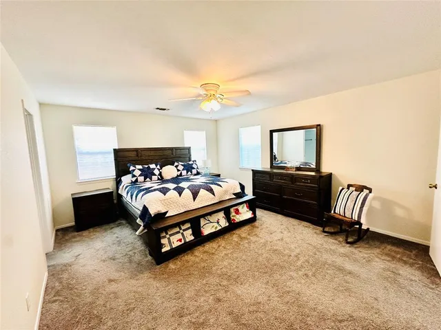 a spacious bedroom with a bed and a chandelier