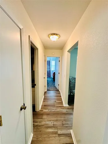 a view of a hallway with wooden floor and staircase