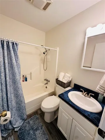 a bathroom with a granite countertop toilet a sink and a bathtub
