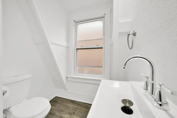 a bathroom with a sink a toilet and shower