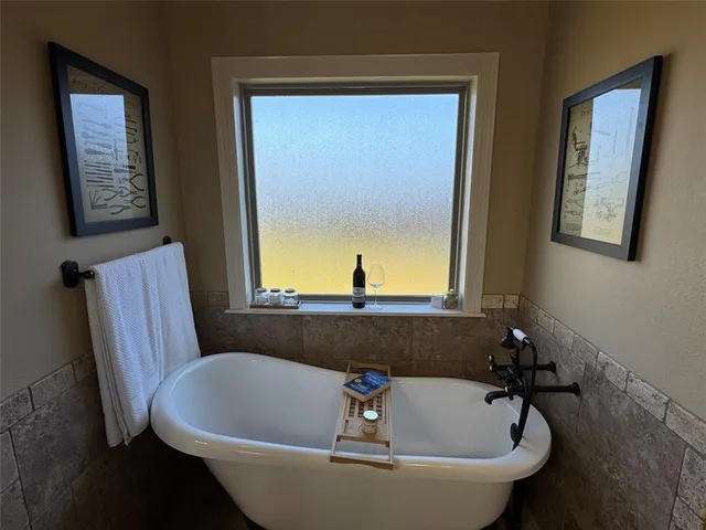 a bath tub sitting in a bathroom next to a window