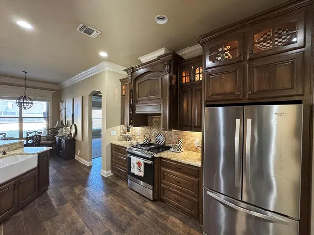 a kitchen with stainless steel appliances granite countertop a refrigerator and a stove