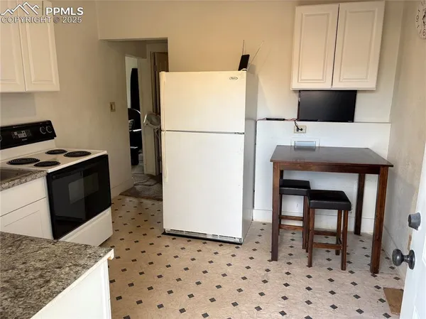 a kitchen with a refrigerator and a stove top oven