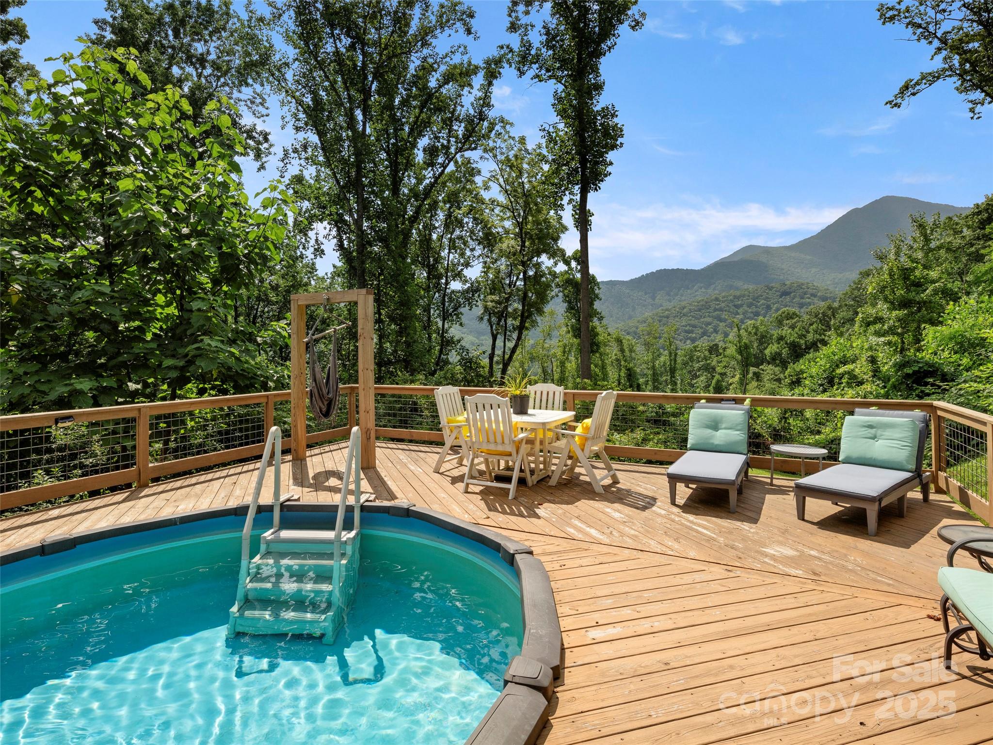 44 Sutton Knob Road Candler, NC 28715 - Photo 11 of 41 a view of a chairs and table on the wooden deck