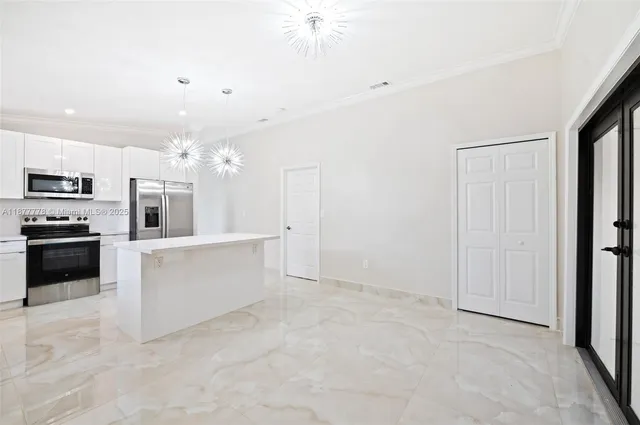 a large white kitchen with cabinets