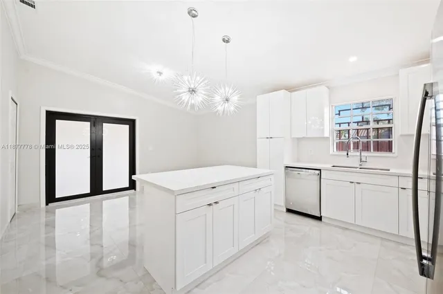 a kitchen with a white cabinets and chandelier