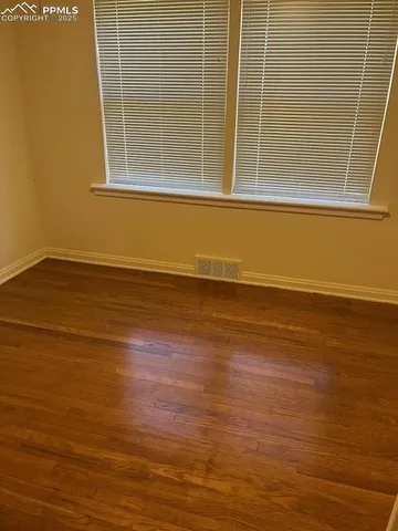 a view of a room with wooden floor and a window