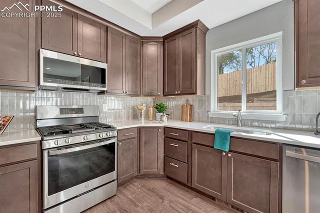 a kitchen with stainless steel appliances a stove sink microwave and cabinets