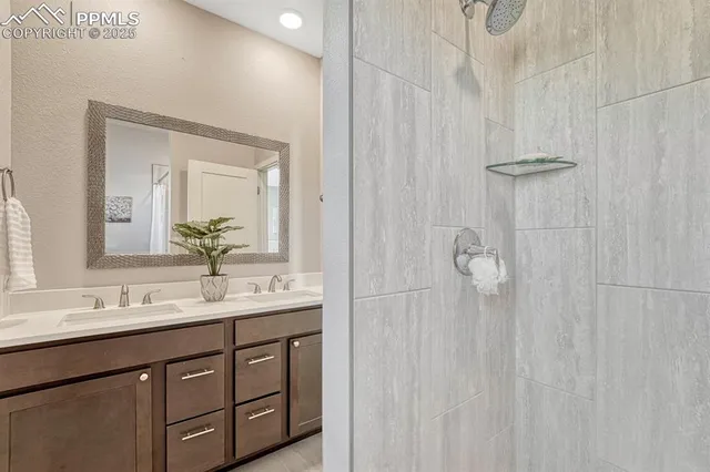 a bathroom with a double vanity sink a shower and a mirror