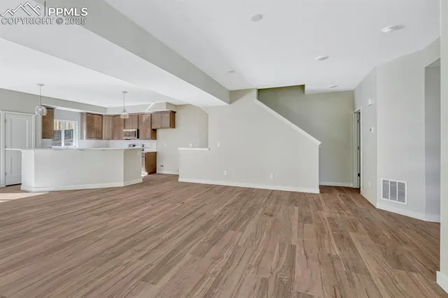 a view of a kitchen with wooden floor and a window
